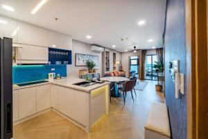 een keuken en een woonkamer met een tafel en een eetkamer bij Aria Resort Vũng Tàu - Căn Hộ & Biệt Thự Nghỉ Dưỡng Có Bãi Biển Riêng Rất Lý Tưởng Cho Gia Đình in Xã Thắng Nhứt