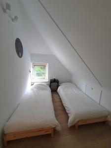 two beds in a attic room with a window at Boshuis 40 in Epe +11 photos