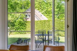 a window view of a patio with a table and chairs at Boshuis 40 in Epe