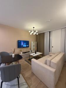 un salon avec un canapé et une télévision dans l'établissement Ugam revers Apartments, à Khumson
