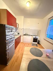 een keuken met een koelkast en een houten vloer bij Geräumige Wohnung Nähe HBF in Eisenach