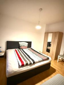 een bed met een gestreepte deken op een kamer bij Geräumige Wohnung Nähe HBF in Eisenach