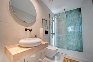 a bathroom with a sink and a toilet and a mirror at Two Levels in Perea