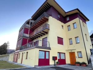 een hoog gebouw met rood en geel bij Luna Rossa Dolomiti in Domegge di Cadore
