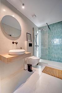 a bathroom with a sink and a toilet and a mirror at Two Levels in Perea