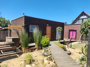 a garden with a wooden walkway in front of a house at RdA Cabaña in Pichilemu