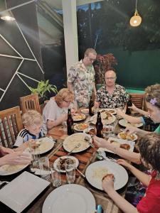 a group of people sitting around a table eating food at Nice View Safari villa in Udawalawe
