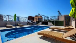a swimming pool with two chairs and a patio at City Point Hotel in Manama