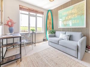 een woonkamer met een bank en een tafel bij Lower Hendra Cottage in Port Isaac