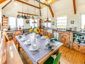 een keuken met een tafel met borden en kommen erop bij Lower Hendra Cottage in Port Isaac +26 foto's