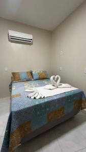 una camera da letto con un letto con una coperta sopra di Pousada Novo Amanhecer a Itarema