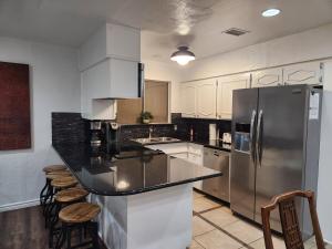 a kitchen with a stainless steel refrigerator and stools at Game Day Getaway in Arlington