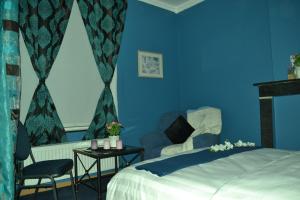 um quarto com paredes azuis e uma cama e cadeiras em Hotel Het Gasthof em Herent