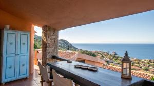 a balcony with a table and a view of the ocean at Casa Cielo Mare in Costa Paradiso