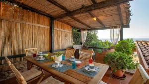 a wooden table and chairs on a patio at Casa Cielo Mare in Costa Paradiso