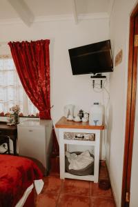 une pièce avec une télévision sur un mur avec une petite table dans l'établissement Gegund Guest Accomodation, à Parys 32 autres photos