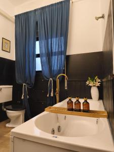 a bathroom with a sink with a blue shower curtain at Visconti apartment and Spa in Catania