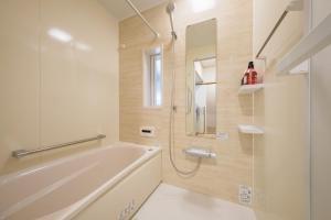 een badkamer met een bad en een glazen douche bij Matsumoto Inn in Matsumoto +58 foto's