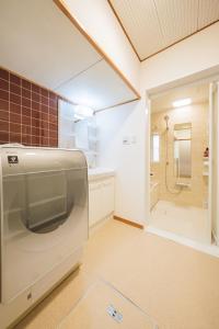 een keuken met koelkast en douche bij Matsumoto Inn in Matsumoto