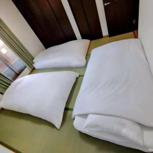 two beds in a room with white pillows at 京旅别莊 in Kyoto