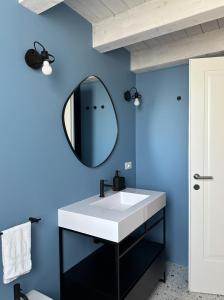 ein Badezimmer mit einem weißen Waschbecken und einem Spiegel in der Unterkunft Tarsilla Appartamenti - Centro Storico in Caorle + 15 Fotos