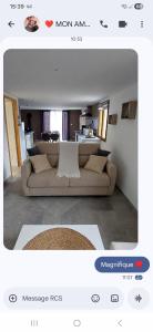 un salon avec un canapé et une cuisine dans l'établissement Gîte LA FONTAINE DU MARAIS, à Pendé