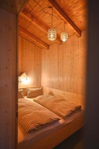 een slaapkamer met een bed in een houten wand bij Garden Apartment in Flachau