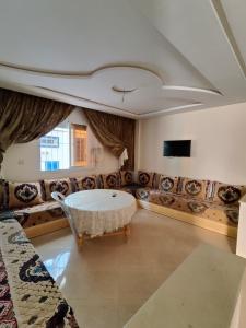 een woonkamer met een bank en een tafel bij Golden Home Tamraght in Tamraght Ouzdar