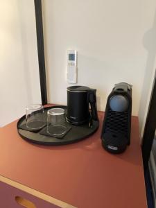 a table with a coffee maker and glasses on it at Casa Oblò in Mendrisio