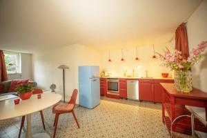 a kitchen with red cabinets and a blue refrigerator at Loft 4 in Schleiden
