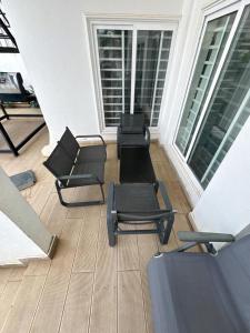 een balkon met stoelen, tafels en ramen bij Villa Soleil, Face a la Mer C1 in Cotonou