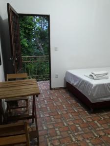 a bedroom with a bed and a table and a window at Áurea da Mata in Cuiabá +6 photos