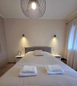 a bedroom with a large bed with two towels on it at Metsovo Fireplace Retreat 2 in Metsovo