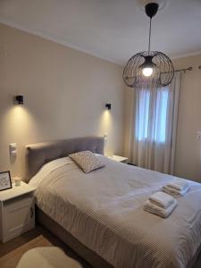 a bedroom with a large bed and a chandelier at Metsovo Fireplace Retreat 2 in Metsovo +23 photos