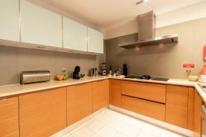 eine Küche mit Holzschränken und einem Herd in der Unterkunft Design Gardens Nº2 in Bicas