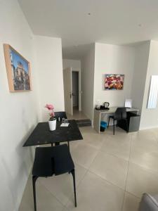 un salon avec une table et des chaises noires dans l'établissement Maqueda Suites, à Palerme