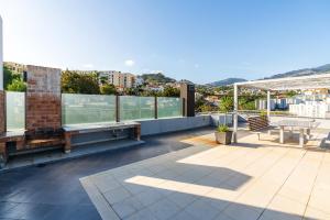 balkon ze stołem i krzesłami na budynku w obiekcie Design Gardens Nº2 w mieście Bicas