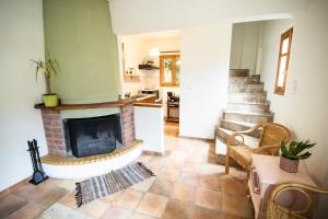 a living room with a fireplace and a kitchen at Strix Aluco Kalavryta in Kalavrita