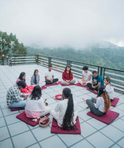 eine Gruppe von Menschen, die in Meditation auf dem Boden sitzen in der Unterkunft Divine Door Wellness Center in Suryodaya