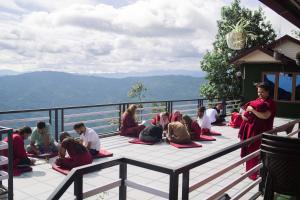 eine Gruppe von Personen sitzt auf einem Balkon in der Unterkunft Divine Door Wellness Center in Suryodaya
