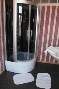 um banheiro com chuveiro e dois tapetes de banho brancos em Hotel Het Gasthof em Herent