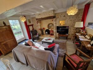 un soggiorno con un divano e una TV di La Chaine a Saint-Jean-du-Bois Altre 17 foto