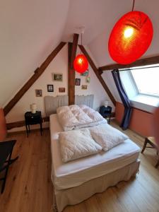 una camera da letto con un letto in una mansarda con luci rosse di La Chaine a Saint-Jean-du-Bois