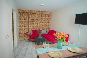 a living room with a red couch and a table at Apparts-hôtel ISNI in Agadir +88 photos