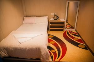 ein kleines Bett in einem kleinen Zimmer mit einem kleinen Tisch in der Unterkunft Divine Door Wellness Center in Suryodaya