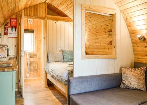 - une petite chambre avec un lit dans une cabane en bois dans l'établissement Lowside Farm Glamping, à Troutbeck