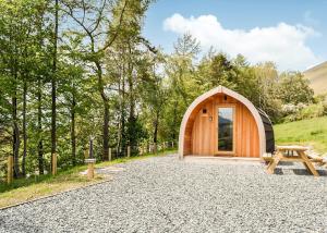 un hangar en bois avec une table de pique-nique et un banc dans l'établissement Lowside Farm Glamping, à Troutbeck