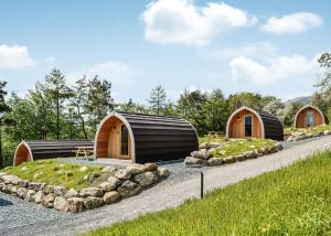 un groupe de trois dômes en bois dans un jardin dans l'établissement Lowside Farm Glamping, à Troutbeck