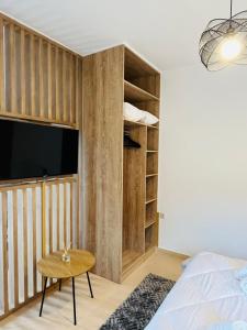 een slaapkamer met een bed, een tv en een tafel bij Onar apartments in Kalavrita
