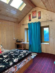 ein Schlafzimmer mit einem Bett und einem blauen Vorhang in der Unterkunft Parashar lake Fogg hill Resort in Prashar lake